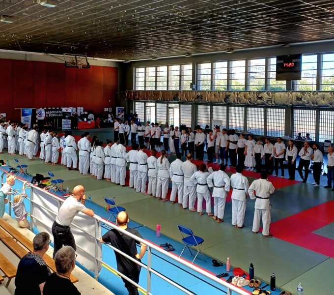 Photo montrant des judokas en ligne sur le tatamis prêt pour le salut face aux officiels du tournoi. Photo prise de la tribune du gymnase.